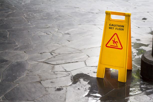 damp floor with a slip hazard sign on it